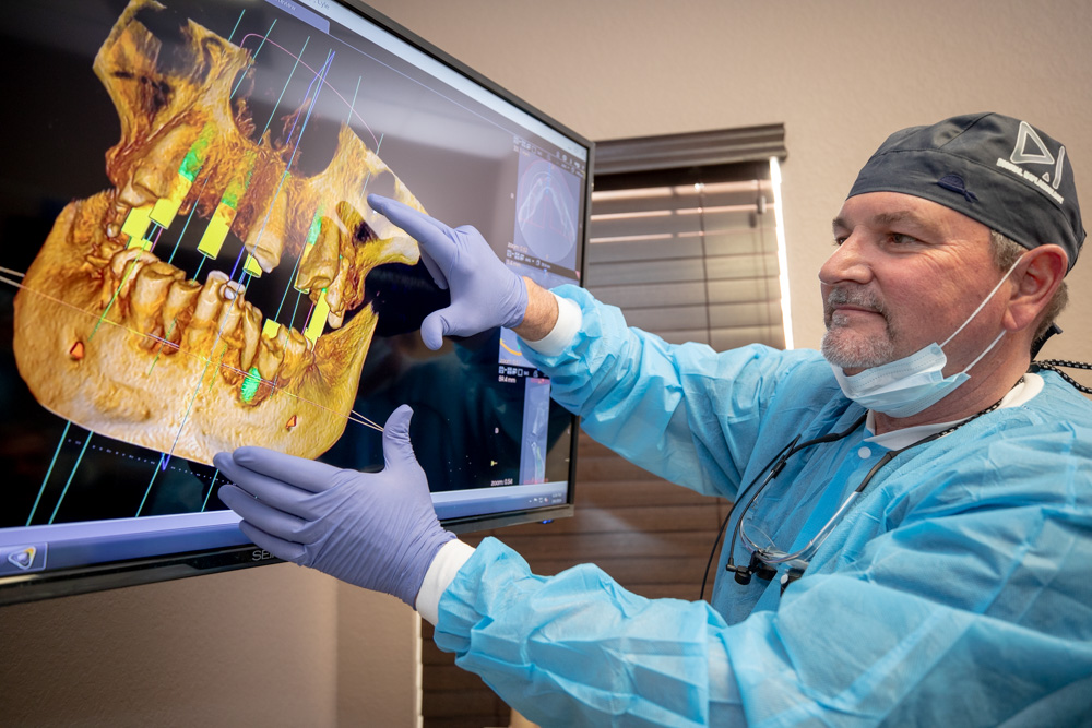 Dr Brand using advanced technology to show placement of full arch dental implants Ocala , FL