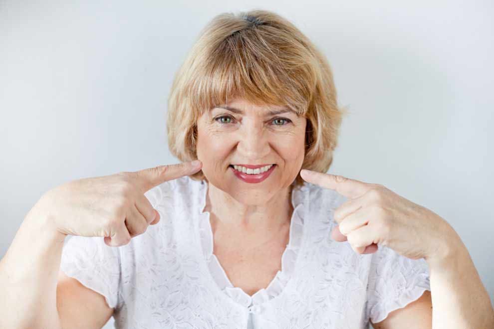 a patient smiling with her new dental implants