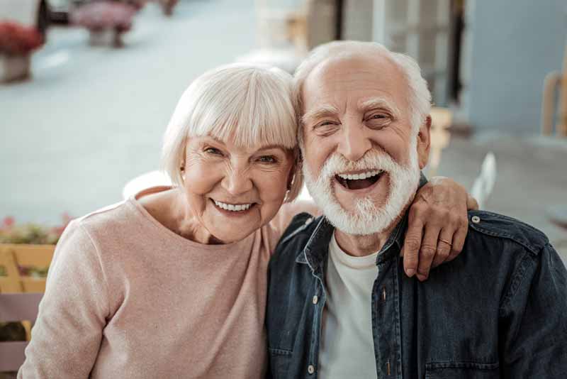 a couple smiling after their dental implant procedure