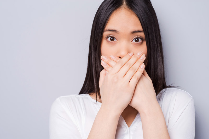 Dental Patient Hiding Her Missing Tooth In Her Smile