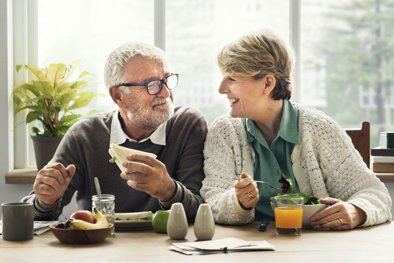 elderly couple enjoying a meal thanks to dental implants