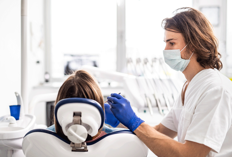 Professional dentist doing teeth checkup on female patient dental surgery