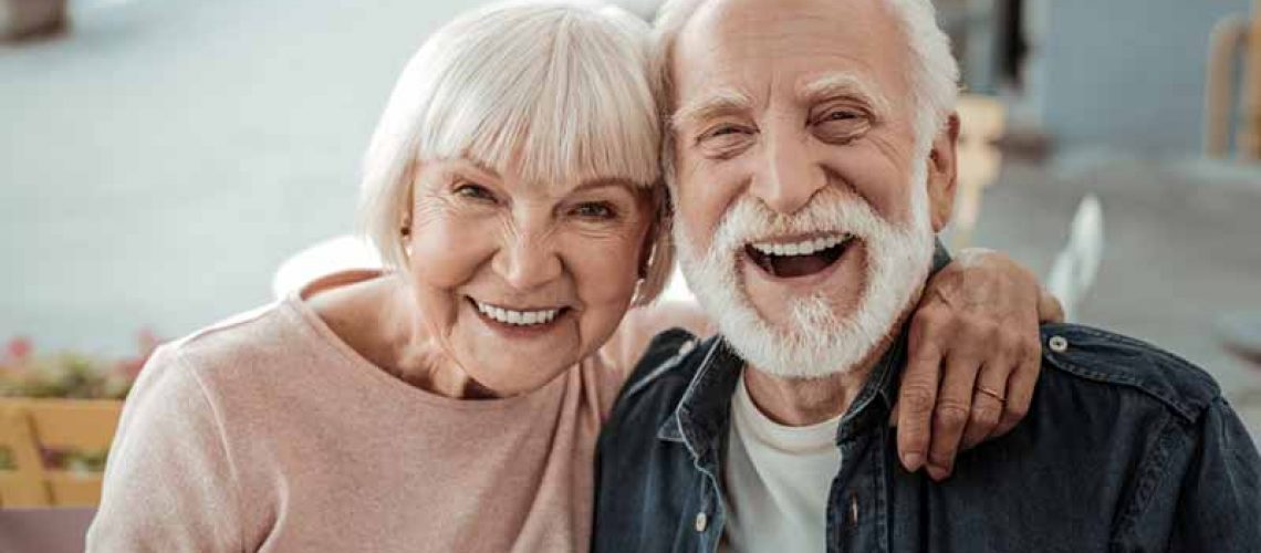 a couple smiling after their dental implant procedure