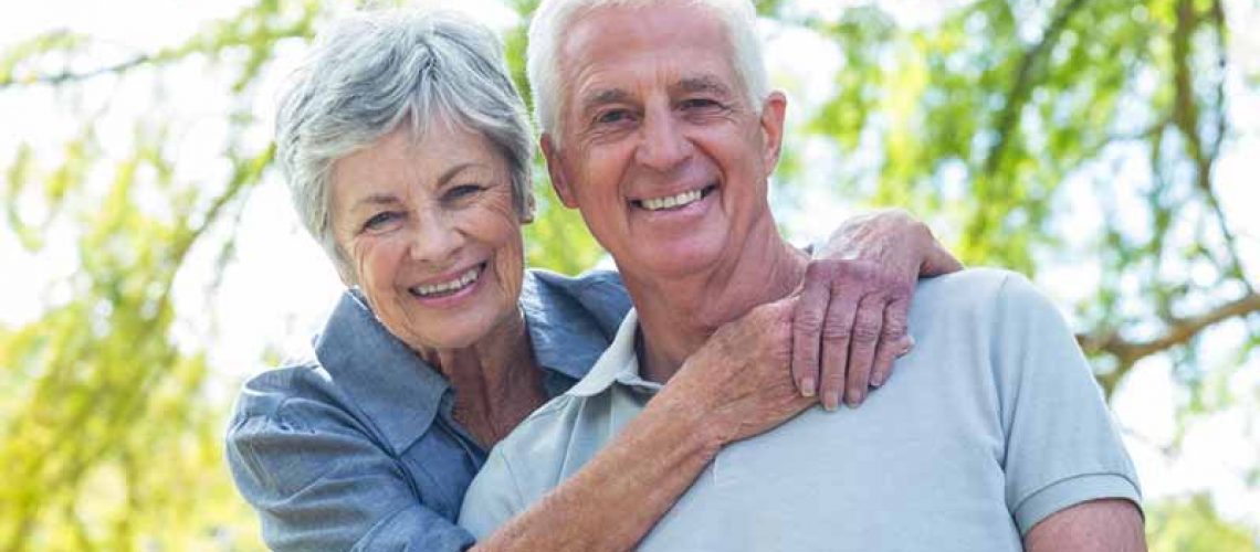 a couple smiling with their newly placed dental implants