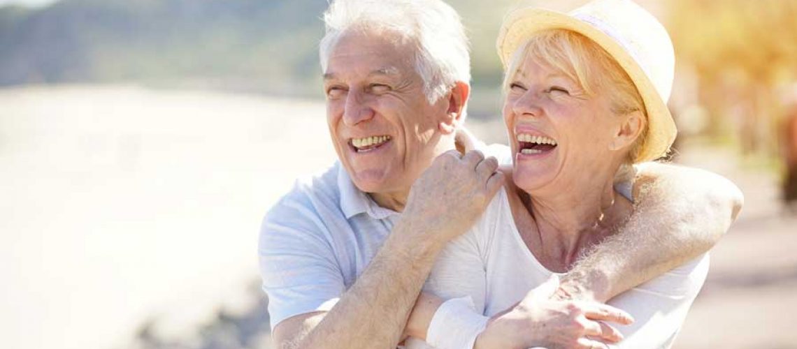 elderly man and women smiling with full arch implants