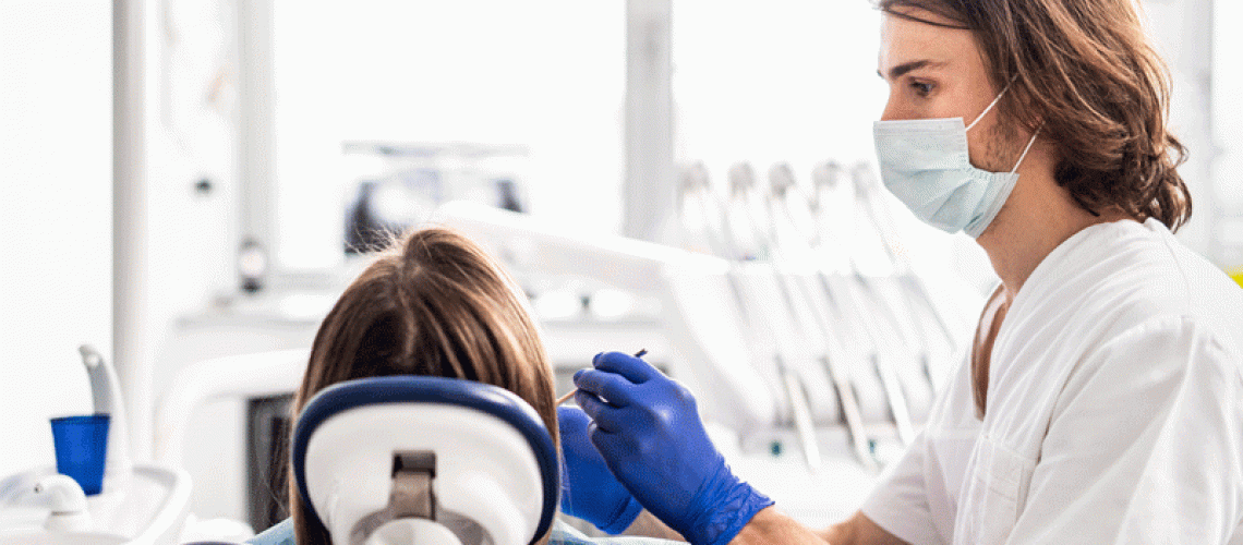 Professional dentist doing teeth checkup on female patient dental surgery