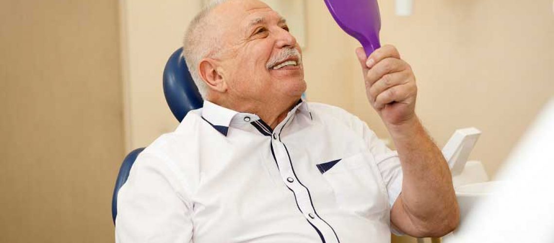 patient smiling with his new implant supported dentures
